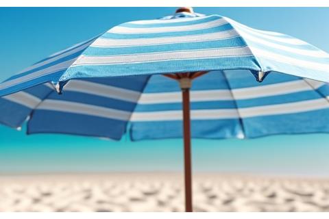 A stylish beach umbrella made from recycled ocean plastic, featuring a subtle wave pattern, standing on a pristine beach.